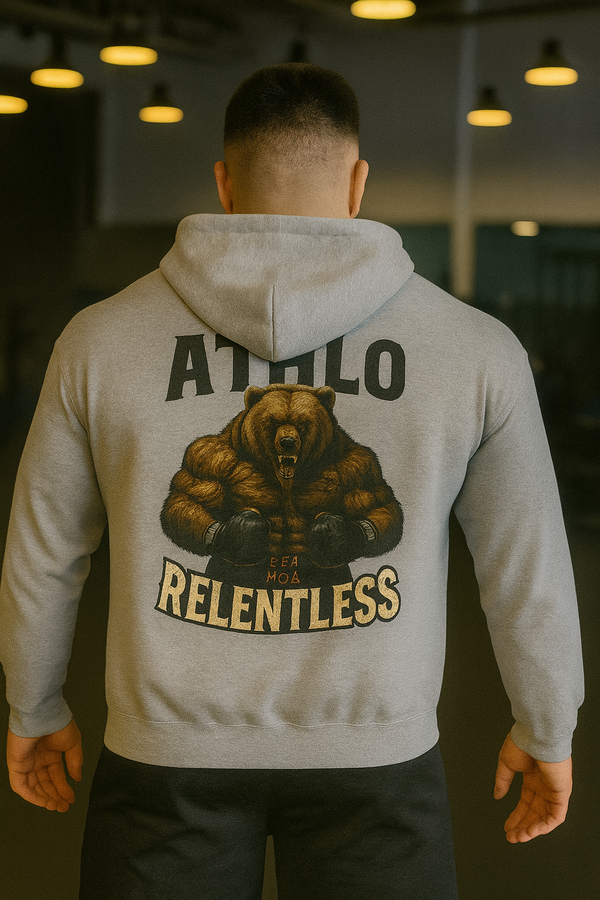 Person wearing a gray hoodie with a bear graphic and text on the back, standing in a dimly lit room.